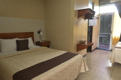 a hotel room with a bed and a balcony at Hotel Las Colinas in Fortuna