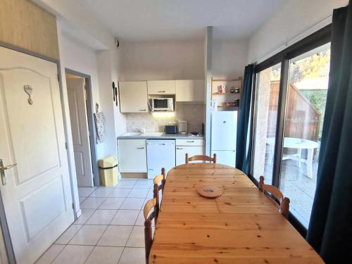 Cette chambre comprend une table en bois et une cuisine. dans l'établissement Résidence Chabrieres - T2 pour 6 personnes à Réallon en rez de jardin CHAB8 MAE-8701, à Réallon