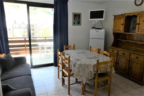 un salon avec une table et un canapé dans l'établissement Résidence Chabrieres - Bel appartement avec 2 chambres pour 6 couchages à Réallon CHAB38 MAE-8711, à Réallon