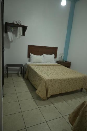 a bedroom with a bed and a tiled floor at Hotel Las Colinas in Fortuna