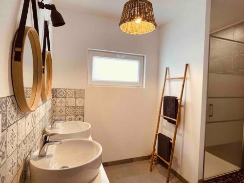 La salle de bains est pourvue de 3 lavabos et d'une rangée de miroirs. dans l'établissement Les Oyats locations, logement Cordouan, aux Mathes