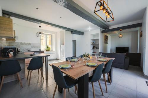 a dining room and kitchen with a wooden table and chairs at Les gîtes Saint-Aignan in Saint-Aignan