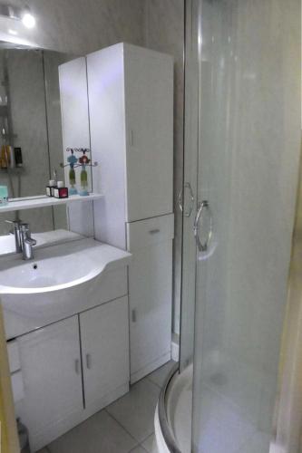 une salle de bain blanche avec un lavabo et une douche dans l'établissement Résidence Aurans - Très joli deux pièces au cœur de la station de Réallon 221A MAE-8801, à Réallon