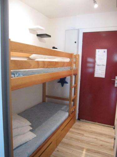 Cette chambre comprend 2 lits superposés et une porte rouge. dans l'établissement Résidence Comete - Superbe studio de 4 couchages à Réallon 106C MAE-8841, à Réallon
