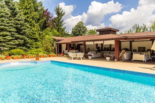 a swimming pool in front of a house at AMARI PARK Residence in Golyama Zhelyazna