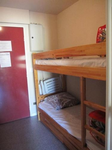 Cette chambre comprend 2 lits superposés et une porte rouge. dans l'établissement Résidence Comete - Appartement 4 couchages bien situé dans la station de Réallon 221C MAE-8861, à Réallon