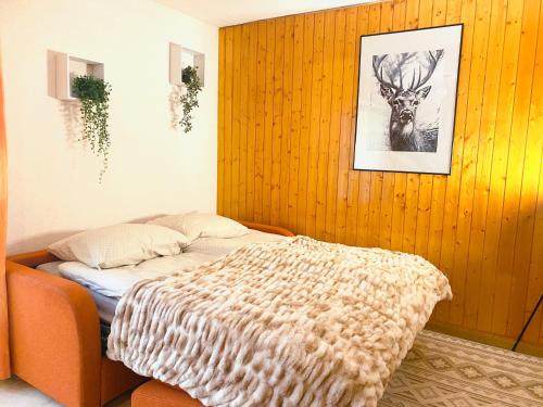 a bedroom with a bed and a picture of a deer at Appartement central Free Parking in Nendaz