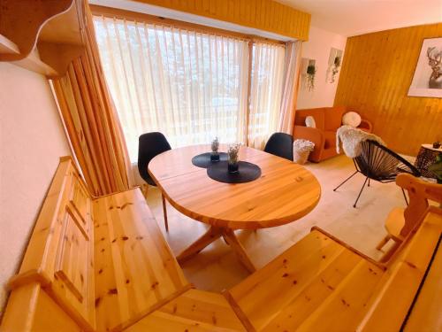 a living room with a wooden table and chairs at Appartement central Free Parking in Nendaz