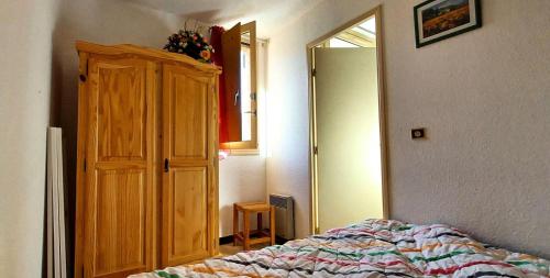 une chambre avec un lit et une armoire en bois dans l'établissement Résidence Relais - Appartement 6 couchages vue montagne à Réallon 126R MAE-8961, à Réallon