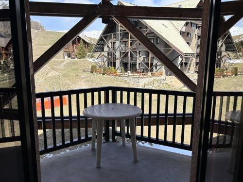 un tabouret assis sur le balcon d'une maison dans l'établissement Résidence Comete - Charmant T2, 6 couchages bien situé dans la station de Réallon 223C MAE-9041, à Réallon