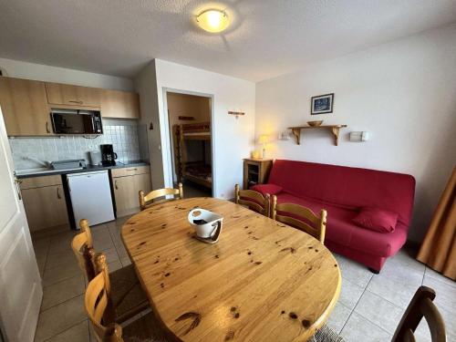 - un salon avec une table en bois et un canapé rouge dans l'établissement Résidence Gardette - Superbe vue sur les montagnes de ce T2 à Réallon A13 MAE-9051, à Réallon