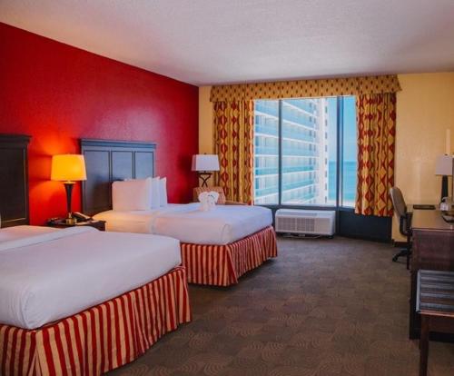 a hotel room with two beds and a red wall at Pier House 60 Clearwater Beach Marina Hotel in Clearwater Beach