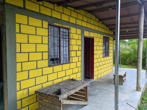 a yellow building with a bench in front of it at Finca el Eden in San Luis
