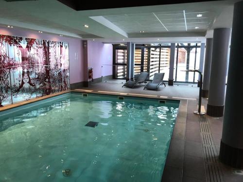 une grande piscine dans une chambre d'hôtel dans l'établissement Résidence Antares - Joli T2 à Risoul près des pistes dans résidence avec piscine/spa MAE-3841, à Risoul