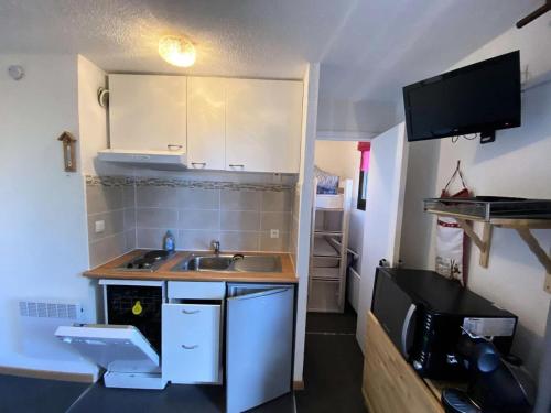 une petite cuisine avec un évier et un micro-ondes dans l'établissement Résidence Christiana - Joli T2 cabine 4 couchages à 50m des pistes à Risoul MAE-6911, à Risoul