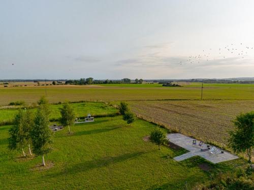 an aerial view of a field with a flock of birds at Domki Ostoja - nad Bałtykiem - cisza i piękno natury in Zastań
