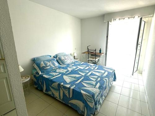 une chambre avec un lit avec une couette bleue dans l'établissement Un air de Venise, à Fréjus