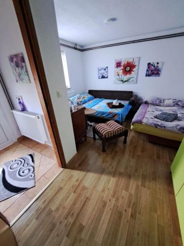 a bedroom with two beds and a table in a room at Stan na dan Kaan in Sarajevo