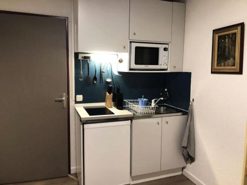 une petite cuisine avec un évier et un micro-ondes dans l'établissement Résidence Edelweiss - Joli studio 4 couchages plein centre et départ des pistes à 50m MAE-7041, à Risoul