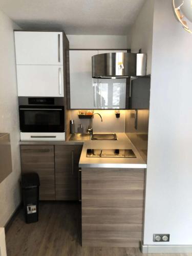 une cuisine avec un évier et un micro-ondes dans l'établissement Résidence Clarines - Charmant studio pour 5 pers. à Risoul 1850 MAE-6951, à Risoul