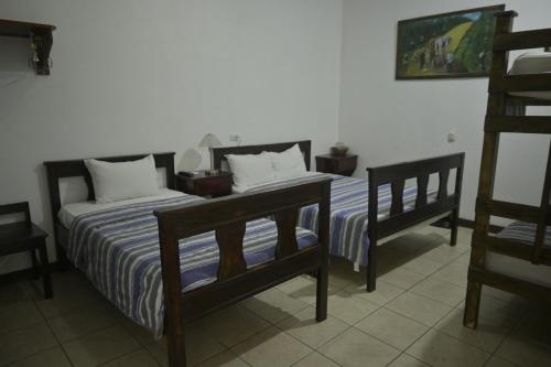 two beds sitting next to each other in a room at Hotel Las Colinas in Fortuna