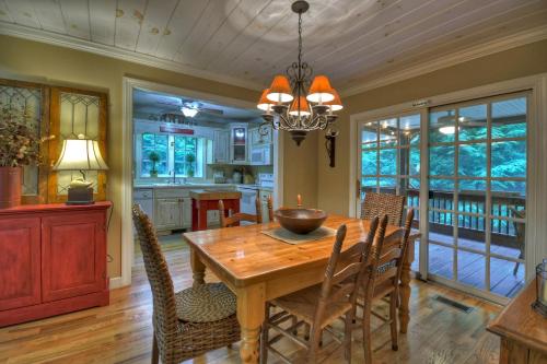 a kitchen and dining room with a wooden table and chairs at Southern Living Cottage Cozy up by the fire relax on the porch and enjoy peaceful surroundings in Blue Ridge