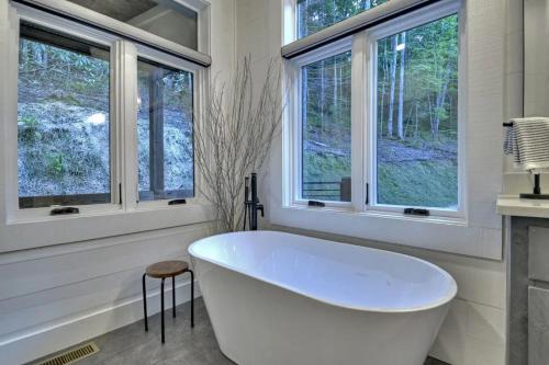 eine weiße Badewanne in einem Badezimmer mit Fenster in der Unterkunft River Bend New listing Modern mountain luxury with amenities galore in Blue Ridge