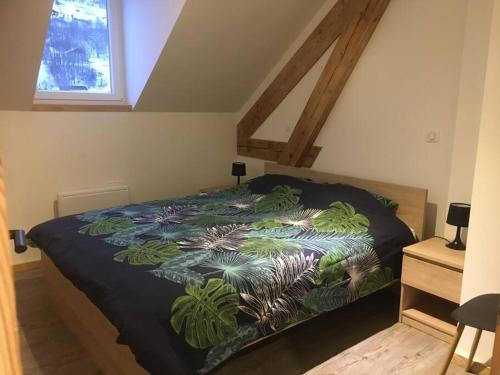 - une chambre avec un lit et une couverture colorée dans l'établissement Appartement Des 2 Vallées,proche de tous commerces, à La Bresse