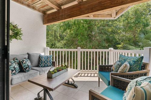 a patio with a couch and a table on a deck at Shipwatch #114 in East End