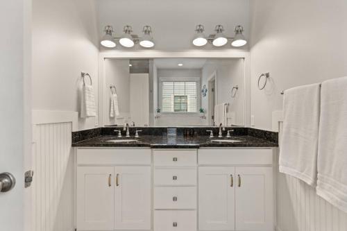 un bagno con due lavandini e un grande specchio di Captain's Hangar a Wymberly-On-The-Marsh