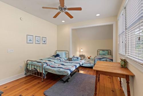 una camera da letto con due letti e un ventilatore a soffitto di Captain's Hangar a Wymberly-On-The-Marsh