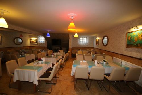 a restaurant with tables and chairs in a room at Selimiye Hotel in Edirne