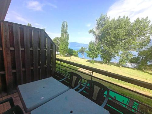 a table and chairs on a balcony with a view of a field at Résidence Voilerie - Studio au bord du lac de Serre Ponçon - Savines le lac STUDLAC MAE-9021 in Savines