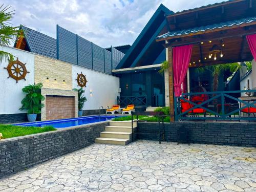 a house with a swimming pool in front of it at Qafqaz Cabana Chalet in Gabala