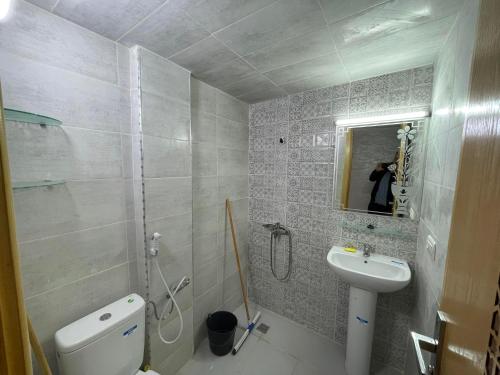 ein Badezimmer mit Waschbecken, Toilette und Spiegel in der Unterkunft Housse Fez City in Fès