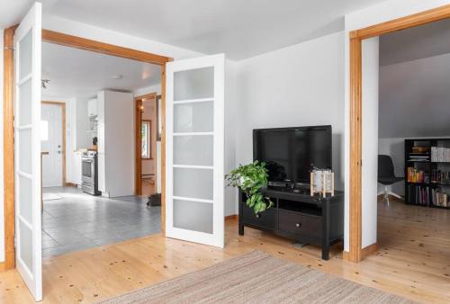 a living room with a flat screen tv on a stand at Bright and Lofty 2BR in Gatineau in Gatineau