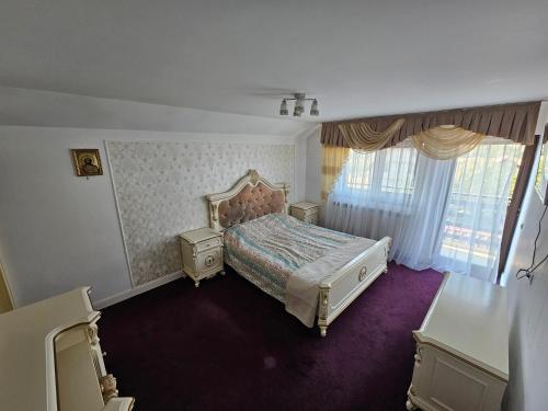 a bedroom with a bed and a large window at Vila Medana- Neamt in Humuleşti