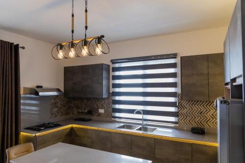 una cocina con fregadero y ventana en Luxury Tropical Oasis 3 BR with Pool close to Beach, en Flic en Flac
