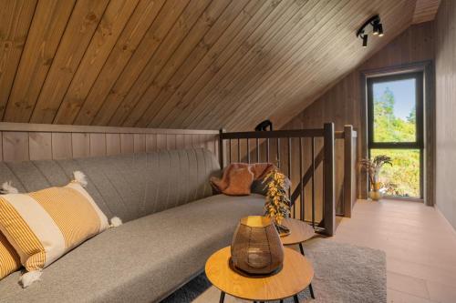 a couch in a room with a wooden ceiling at Stryn Wiew Logde Tverrfjellet in Stryn