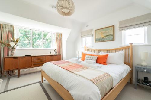 Un dormitorio con una cama, un escritorio y ventanas. en Chantries, en Bembridge