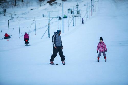 a man and a child on a snowboard in the snow at Bakuriani, Crystal Resort Block C, 429 in Bakuriani