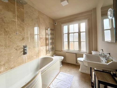 a bathroom with a tub and a sink at The Mozart Suite by Sloane Square in London