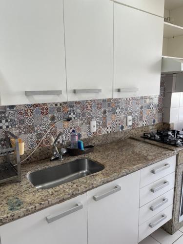 a kitchen with white cabinets and a sink at Barra Family Resort com piscina e spa, 2 quartos in Rio de Janeiro