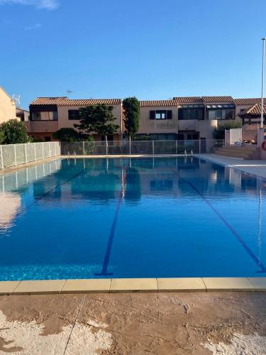 une grande piscine devant un immeuble dans l'établissement T2 village naturiste Aphrodite, à Leucate