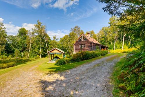 a dirt road next to a barn and a house at Cozy Home on 10 Acres Yellowstone in Vermont in Townshend