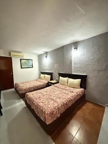 a hotel room with two beds in a room at Hotel Narváez Dorado Centro de Convenciones in Tuxtla Gutiérrez