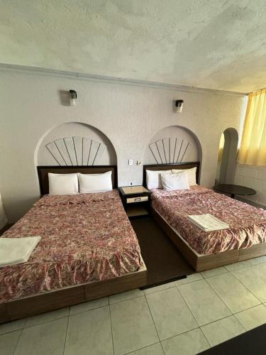 two beds sitting next to each other in a room at Hotel Narváez Dorado Centro de Convenciones in Tuxtla Gutiérrez