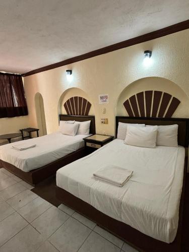 two beds in a hotel room with two beds at Hotel Narváez Dorado Centro de Convenciones in Tuxtla Gutiérrez