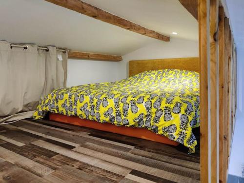 - une chambre avec un lit et une couette jaune dans l'établissement Studio indépendant, à Saint-André-de-Sangonis