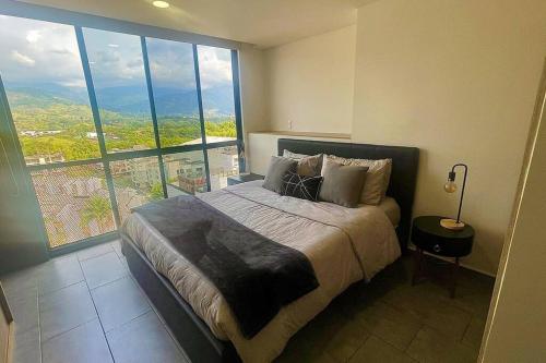 Ένα ή περισσότερα κρεβάτια σε δωμάτιο στο Apartamento Exclusivo Frente al Mall con WiFi, Parqueadero y Vista Panorámica